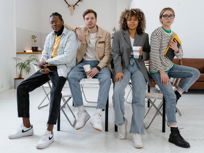 A diverse group of young professionals sitting together in a modern office setting, promoting teamwork.