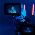 Close-up of a woman singing during a music video shoot with a focus on the camera screen.