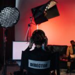 Film director in chair with headphones in a studio setting.