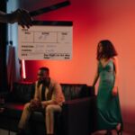 Actors on a film set with a clapperboard signaling action.